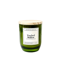 Green candle with a wooden lid and label on a white background